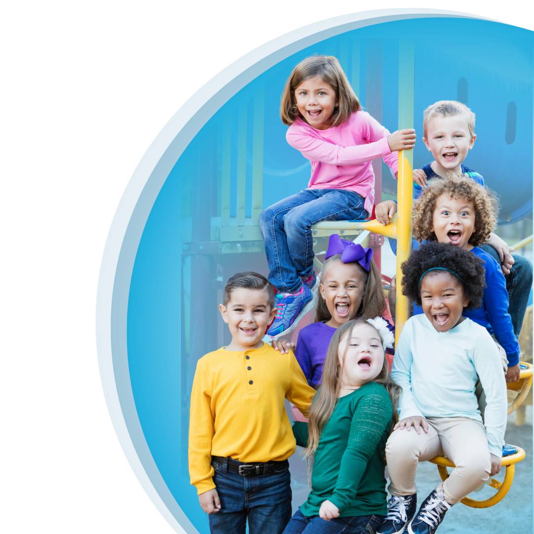 A group of children smiling on the playground with a blue background